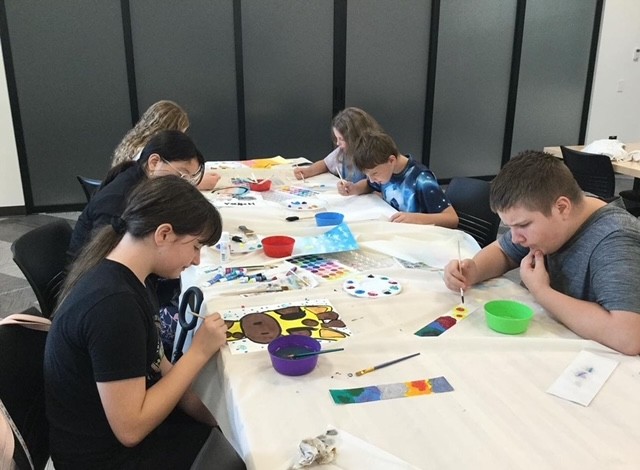 six teens painting inside the library
