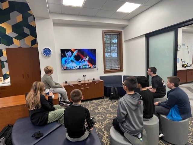 Group of seven teens playing a switch game in a semi-circle